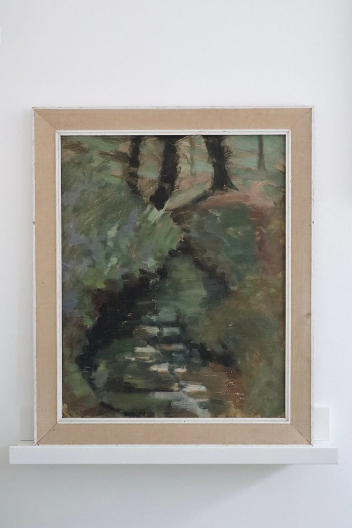 Framed painting of a natural scene with green and brown tones on a white wall.