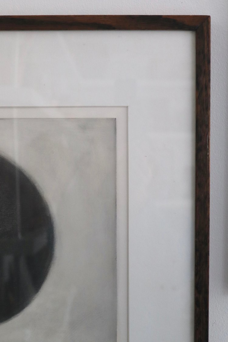 Framed artwork with a dark brown border on a light gray wall.