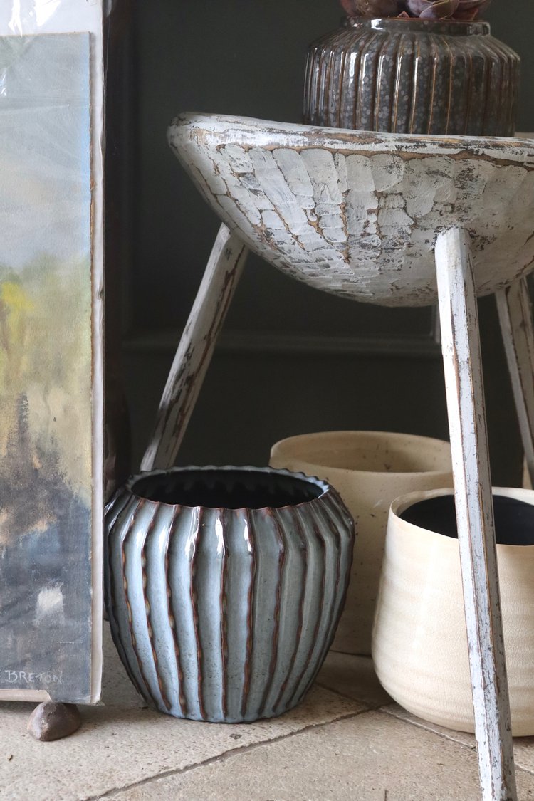 Decorative ceramic pots on a wooden stand with a dark background