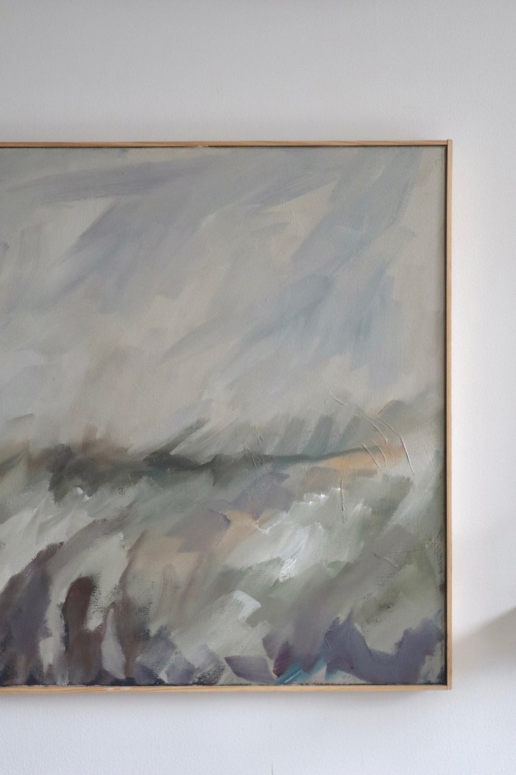 Abstract painting in a gold frame on a white wall