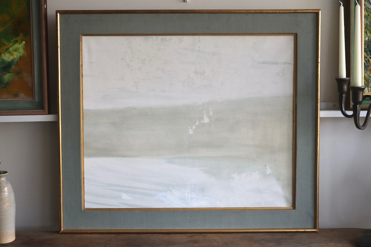 Framed abstract painting on a wall with a neutral color palette