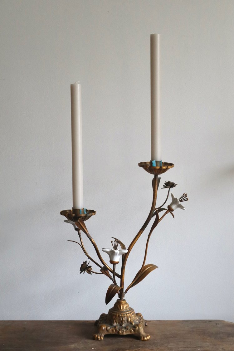 Decorative candle holder with two candles on a plain background