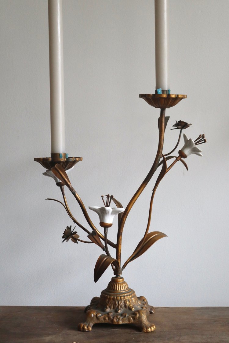 Decorative candle holder with floral design against a plain background