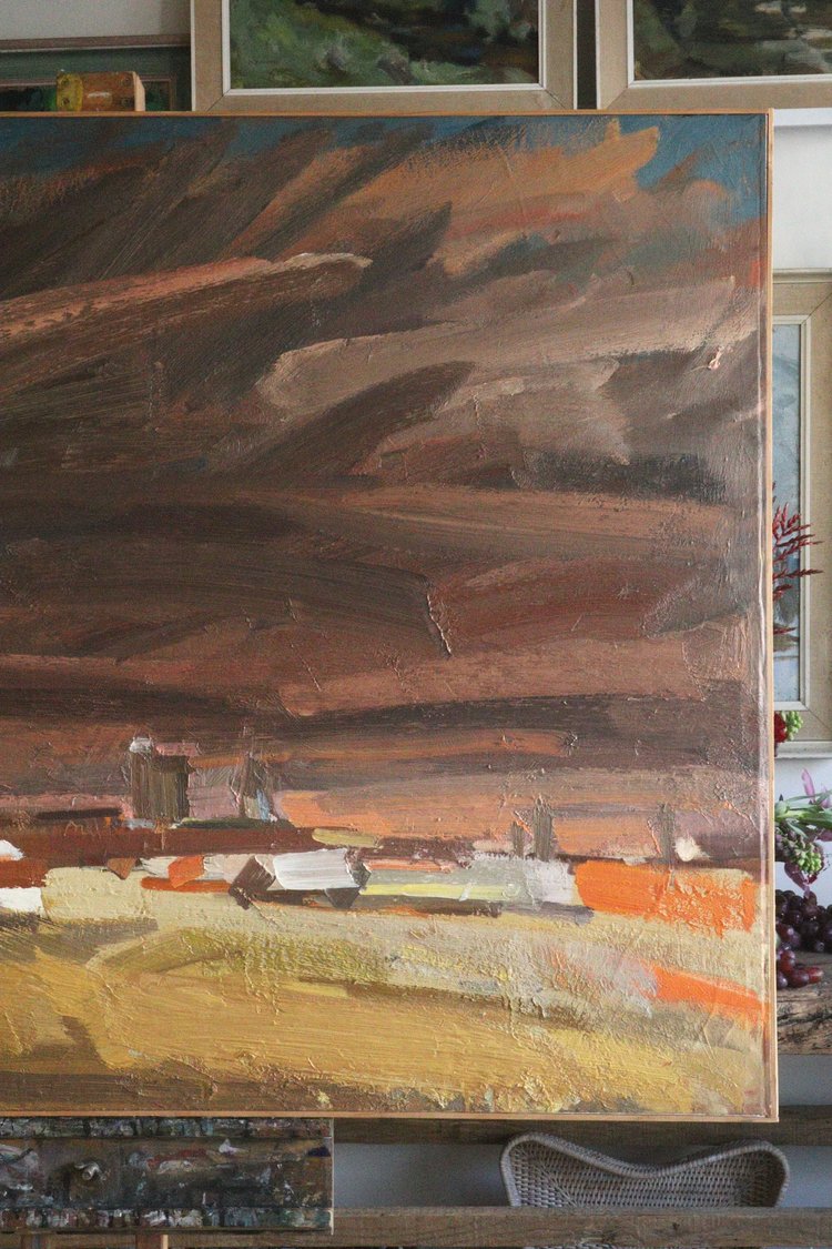 Abstract painting with brown, orange, and yellow hues on a wall.