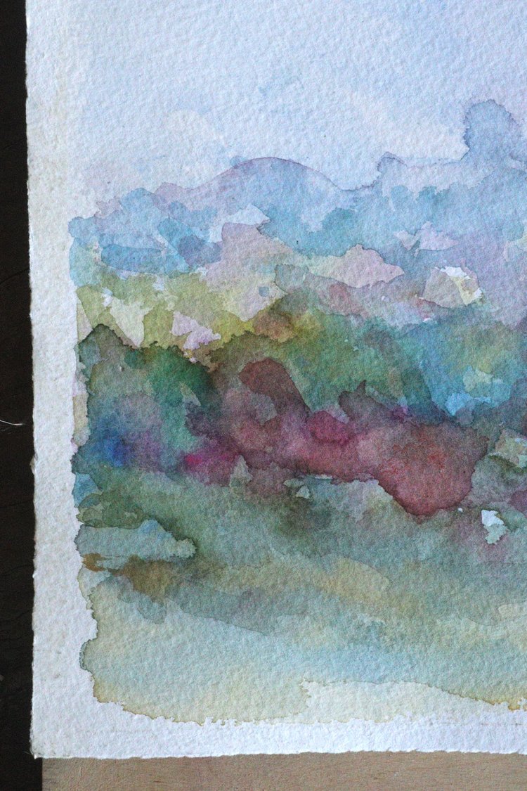 Watercolor landscape with colorful clouds and greenery on a white background
