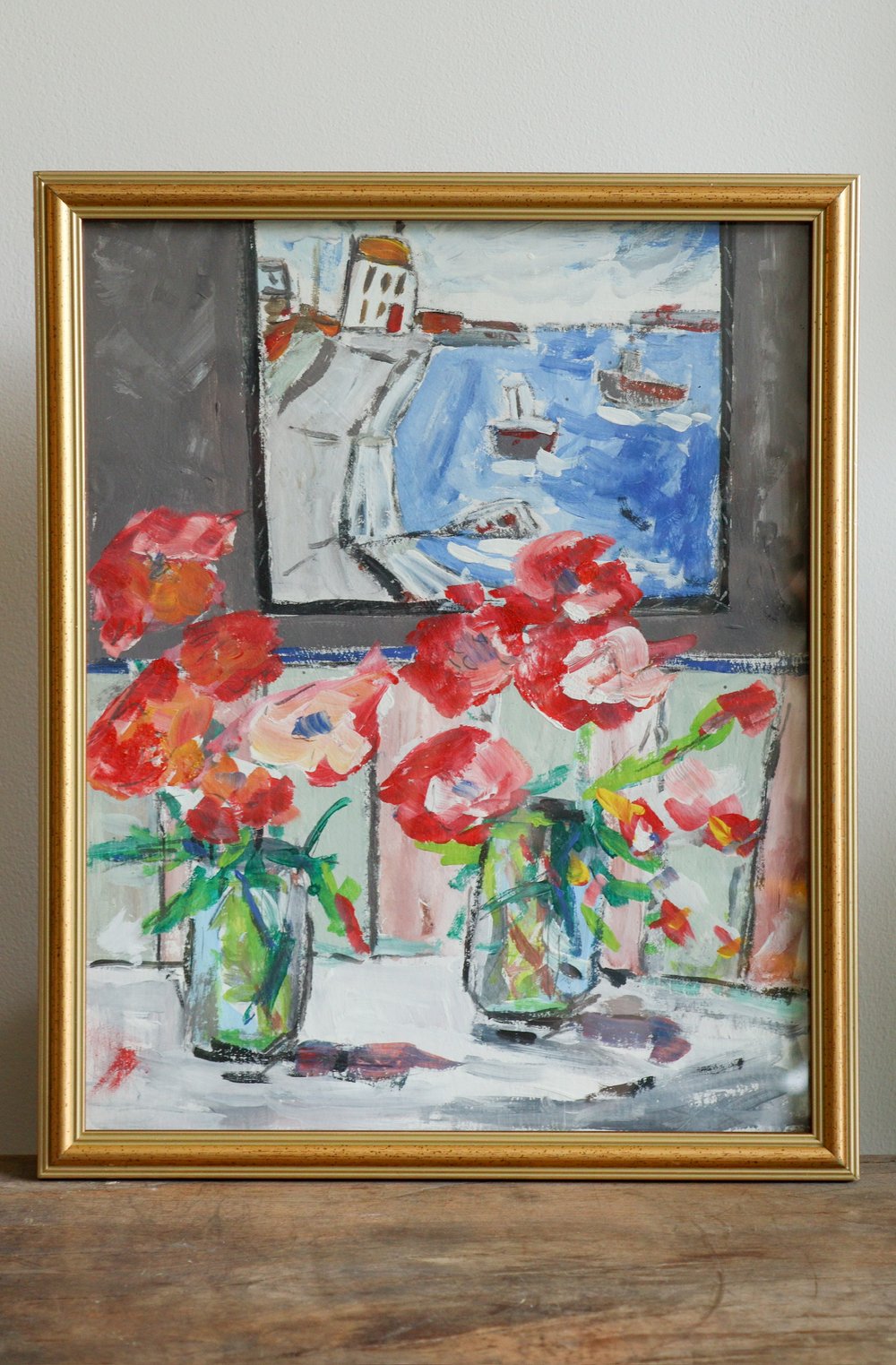 Framed artwork with flowers and a coastal scene.