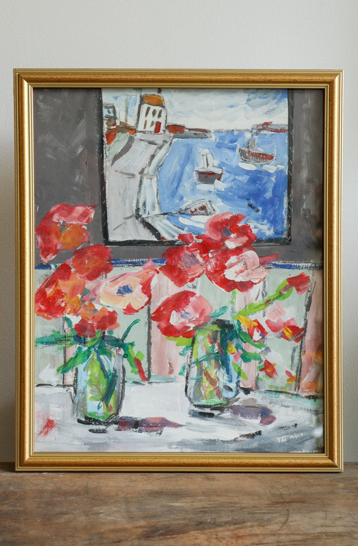 Framed artwork with flowers and a coastal scene.