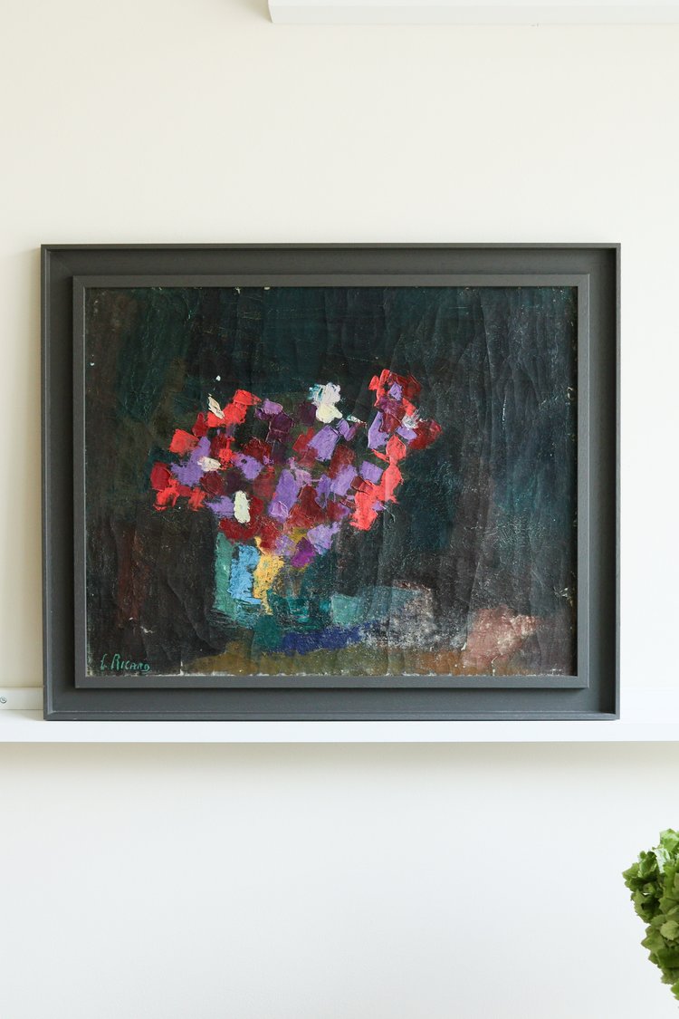 Framed painting of a bouquet of flowers on a white wall
