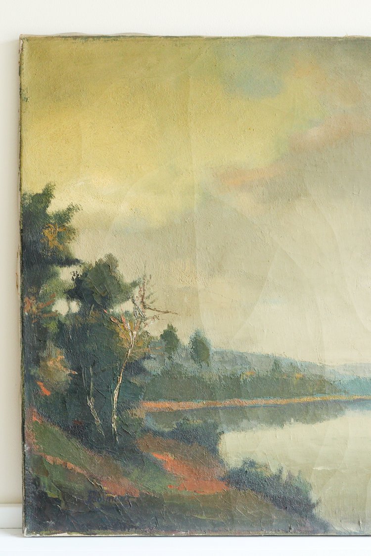 Painting of a landscape with trees and water on a white wall.