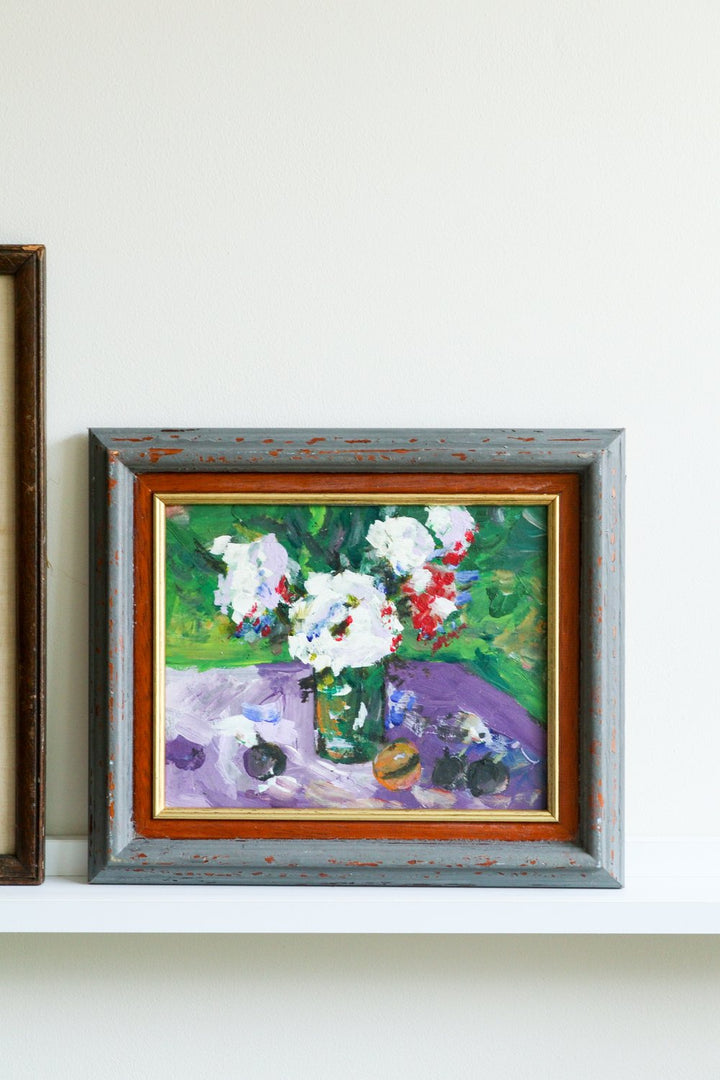 Framed painting of flowers on a white wall