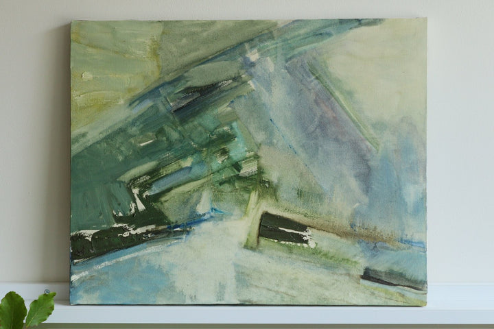 Abstract painting with green and blue tones on a white wall