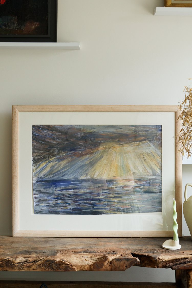 Framed abstract painting on a wooden surface with a neutral background