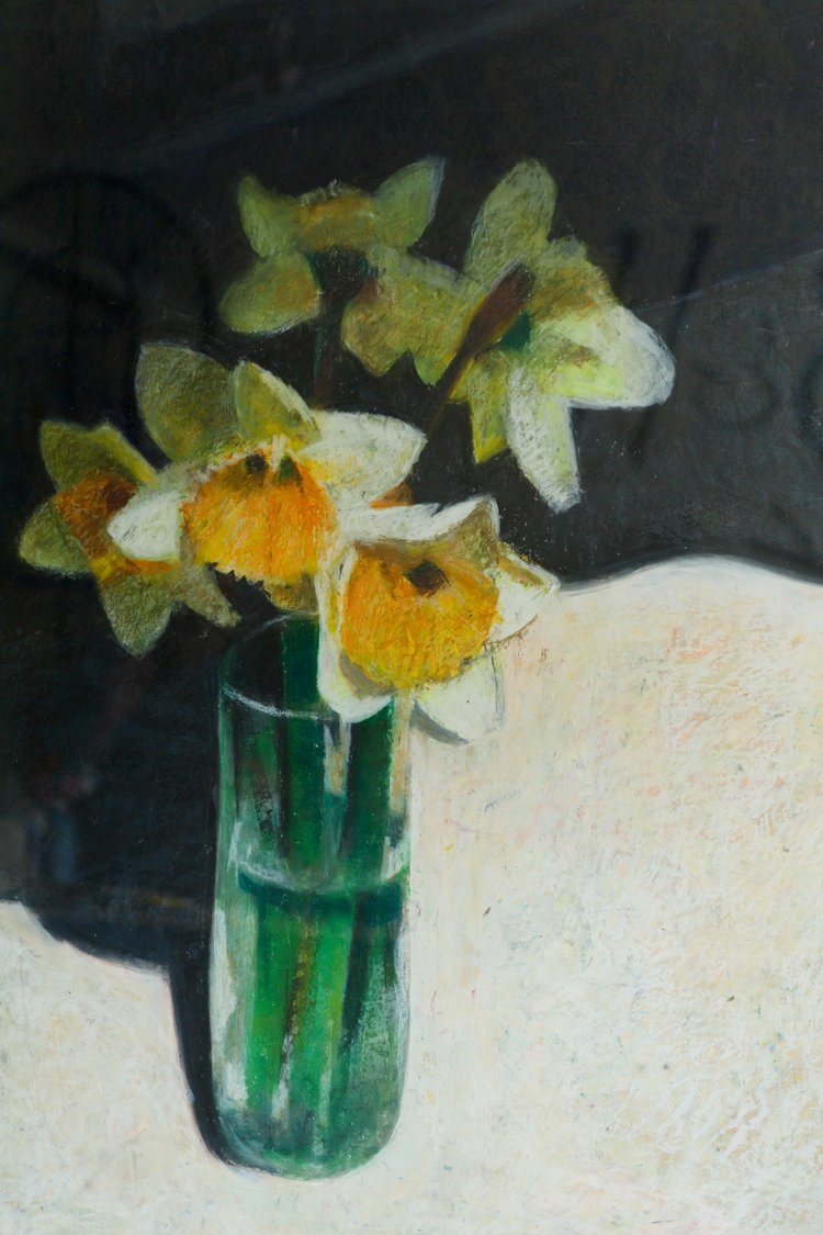 Vase with daffodils on a textured surface