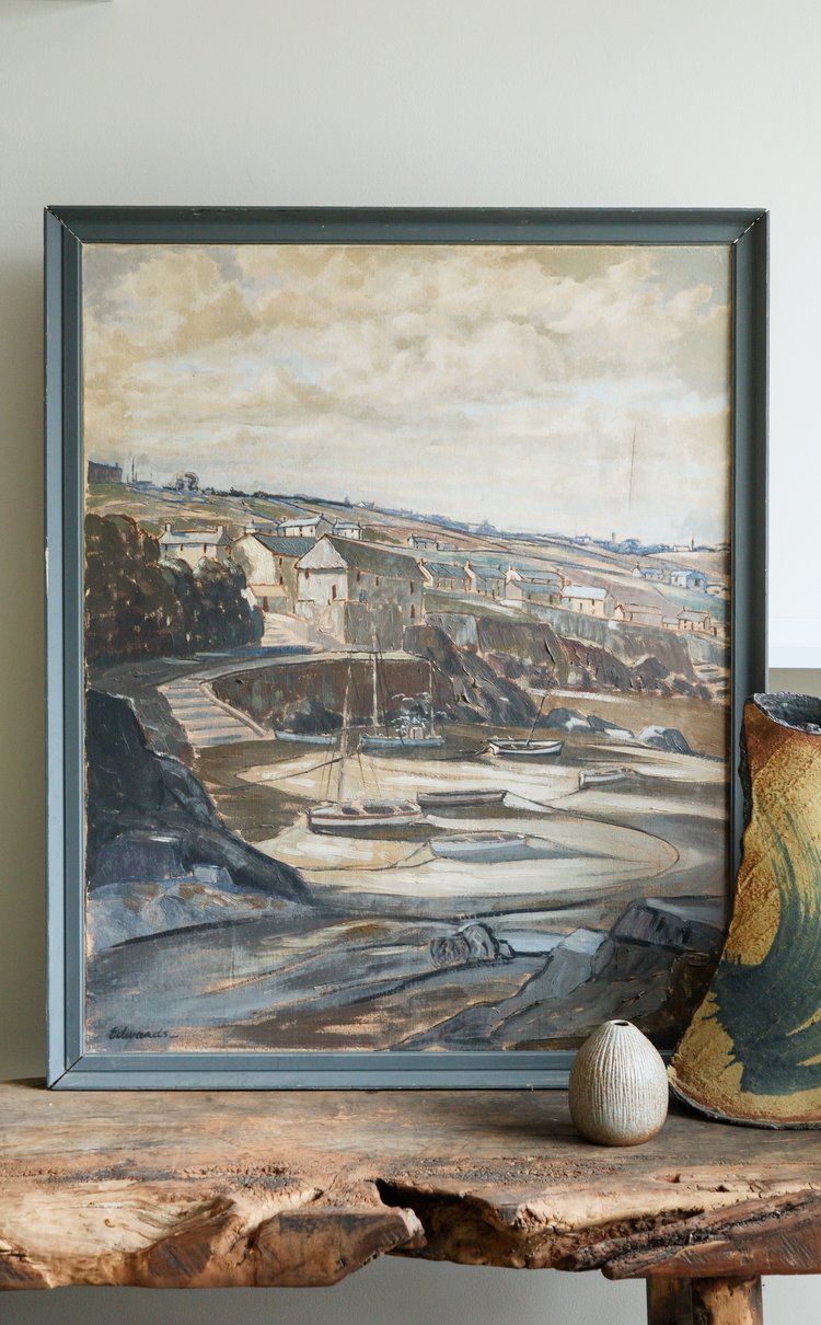 Framed painting of a landscape scene on a wooden table