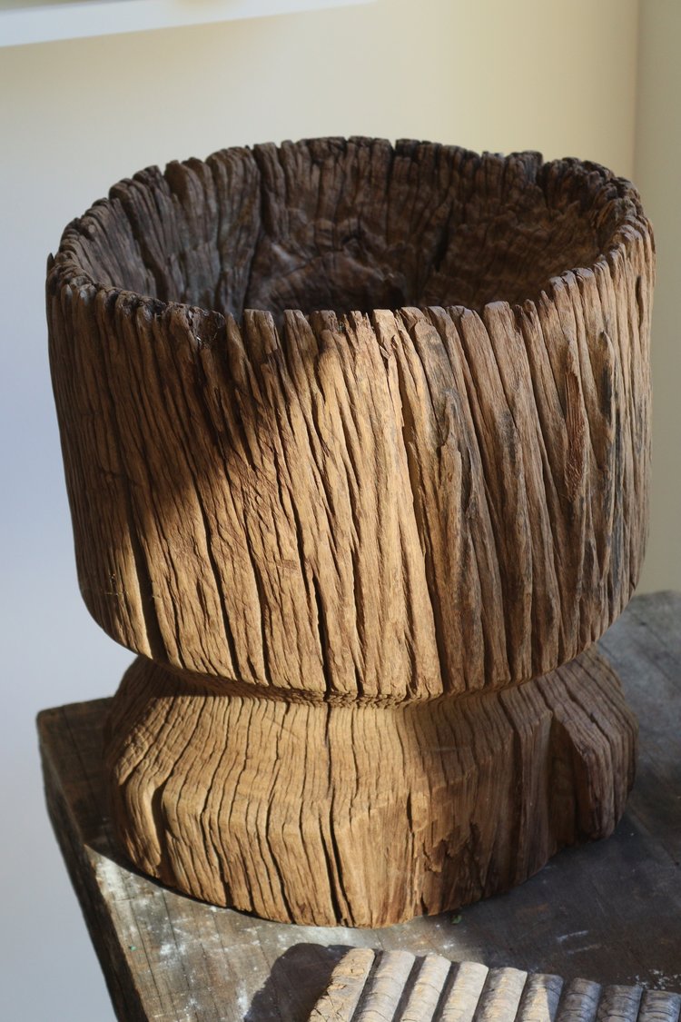 Wooden planter with a textured surface on a reflective surface