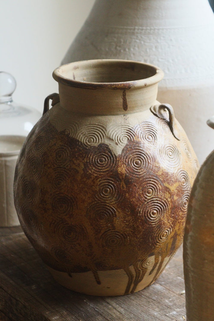 Decorative ceramic jar with textured surface on a wooden surface