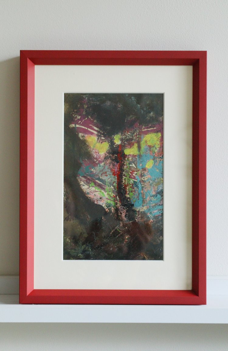 Framed abstract artwork with a red border on a white wall