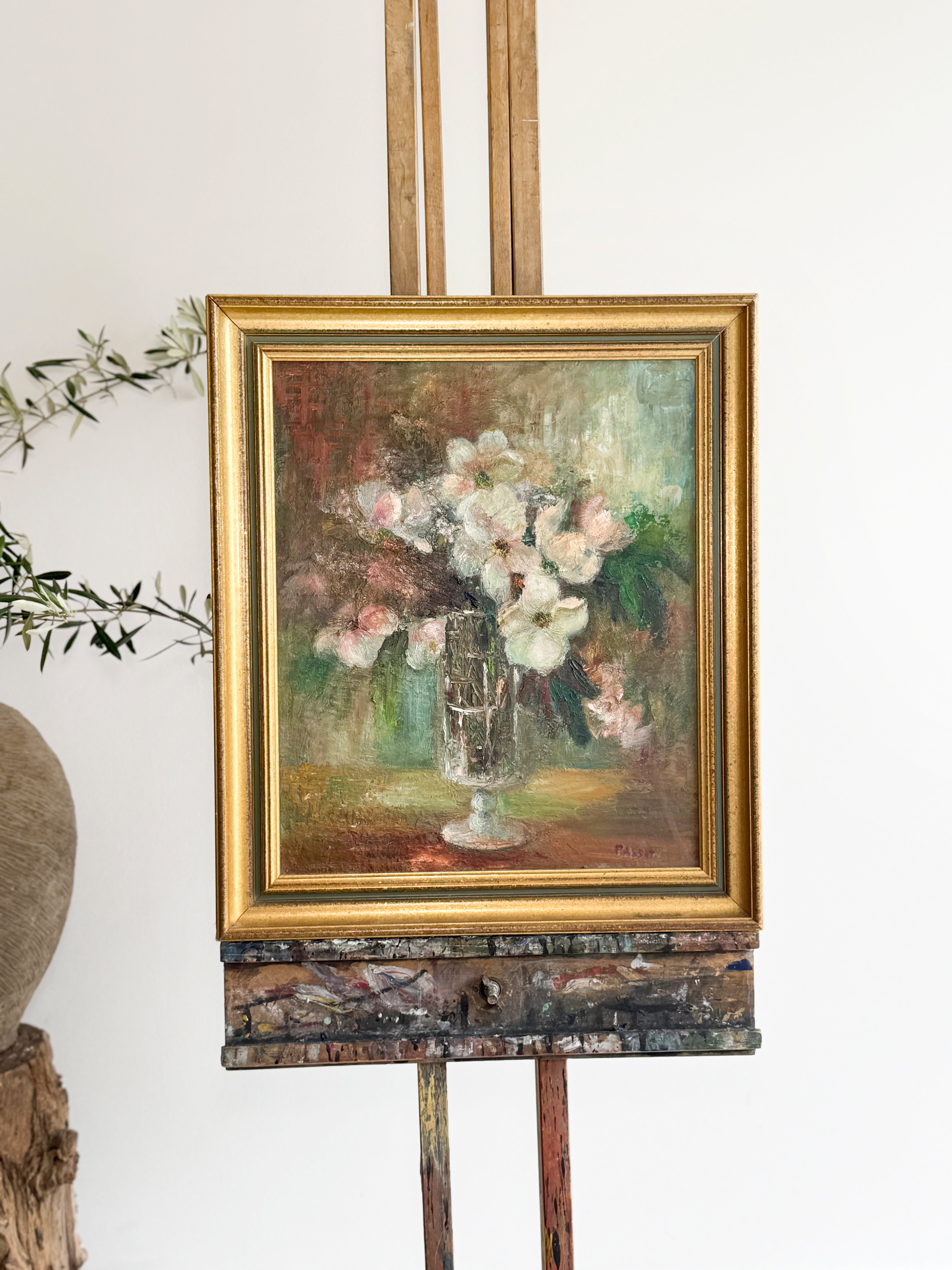 Vintage painting of flowers on a wooden easel against a white wall. Online antiques and art