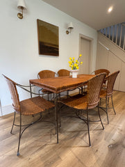 Woven Rattan Dining Table & 6 Chairs. Vintage rattan dining table and six chairs with woven top and metal legs. Elegant, lightweight design for kitchen or dining spaces.
